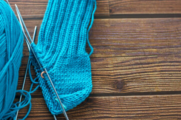 Knitting a warm sock from blue wool yarn