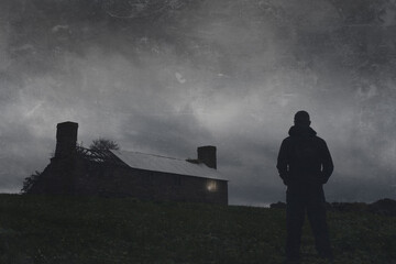 A ruined house in the middle of the countryside. With a light shining from a broken window on a...