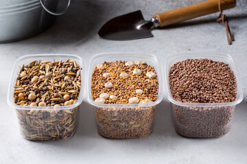 Green manure, siderates. Three types of seed mix fast growing green manure in plastic containers on concrete background. Organic farming.
