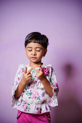 Indian little Girl doing mathematics by counting fingers at home