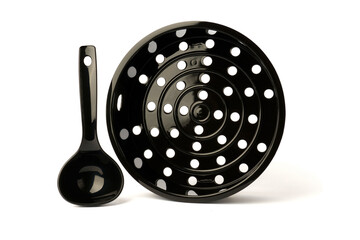 black mesh multicooker steamer with plastic spoons for cooking isolated on white background.