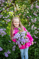 Little cute and beautiful girl holding a lilac and smiling. happiness and family concept