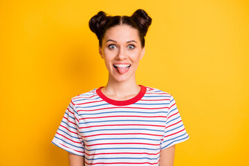 Photo of charming fooling young lady dressed striped outfit showing tongue isolated yellow color...