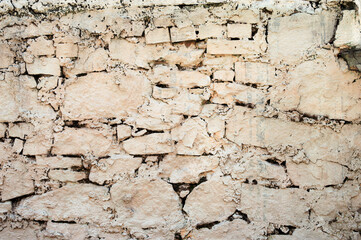 Ancient stone wall. Ruin. Gray stone background. Wall with peeling plaster.