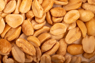 Roasted salted peanuts, surface texture. Close-up, selective focus.