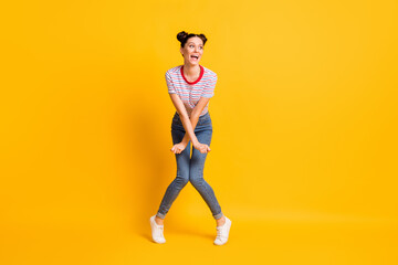 Fototapeta na wymiar Photo of funky sweet young lady wear striped t-shirt dancing looking empty space isolated yellow color background