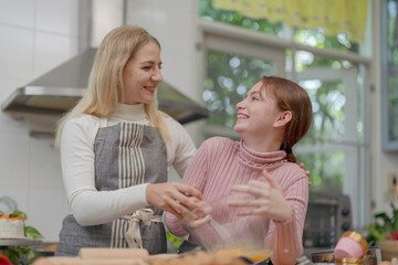 Mother and daughter preparing tasty food and bakery at kitchen. Mommy teaching daughter to cook.