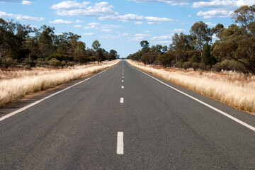 Fototapeta premium Cobar Australia, view along flat straight asphalt rural road.