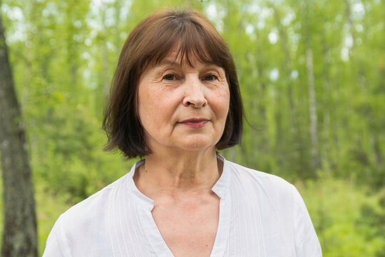 Portrait of one woman 60 years old in a summer forest