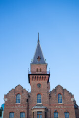 Fototapeta premium Looking up at old tower against blue sky
