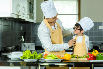 Cooking Family. Chef parent and kid boy make fresh vegetables salad for healthy eat.  Asian son helping make food, so happy and enjoy