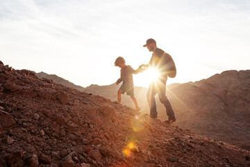 Dad with son in the mountains in the desert - 438406561
