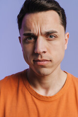 Fototapeta premium Young brunette white man frowning and looking at camera