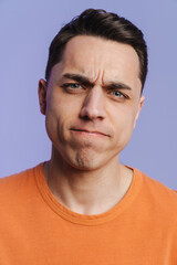 Fototapeta premium Young brunette white man frowning and looking at camera