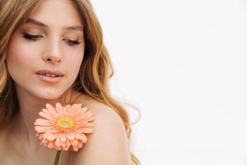 Half-naked blonde woman posing with gerbera flower