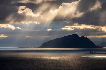 Naklejka na ściany i meble Sunbeams from at dark clouds in a beautiful seascape view