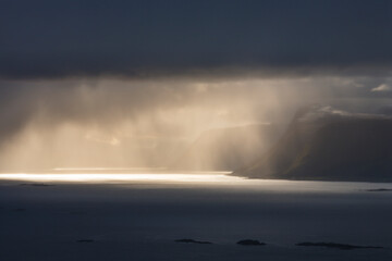 Sunbeams over rocky coastline in Norway