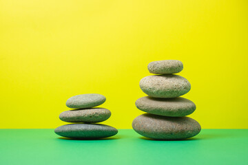 Flat stones stacked on top of each other on a colored background. The concept of calmness and balance