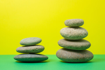 Fototapeta na wymiar Flat stones stacked on top of each other on a colored background. The concept of calmness and balance