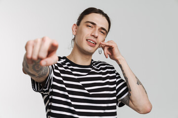 Young white man with earring gesturing and pointing finger at camera