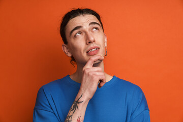 Young white man with earring posing and looking upward