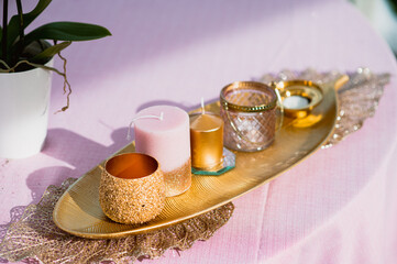 Elegant centerpiece on a table with candles golden details and flowers. wedding decoration.