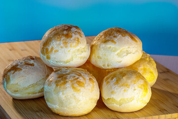 baked and fresh cheese bread on a wooden table