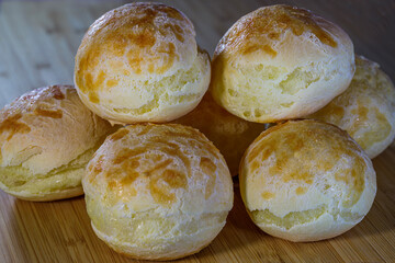 baked and fresh cheese bread on a wooden table
