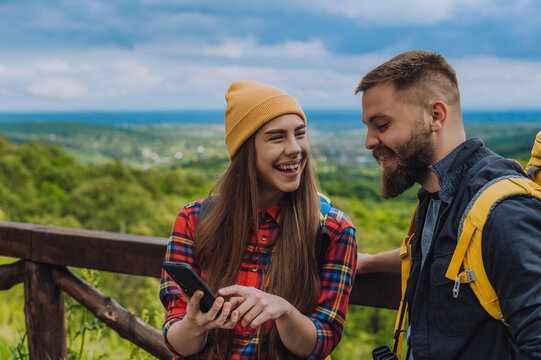 A couple of hikers using smartphone for orientation while spending time in nature - Powered by Adobe