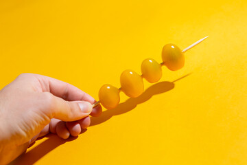 a skewer of cherry tomatoes over orange background