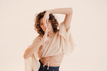 Young hispanic woman with curly hair dancing on camera