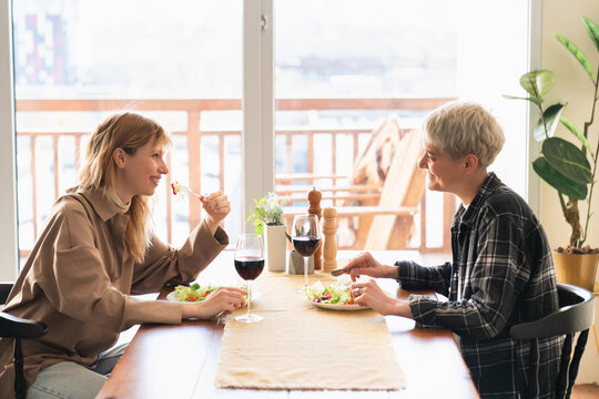 Two Beautiful Caucasian Lesbians Having Romantic Date Dinner Together Drinking Wine. Love And Lelationship, Female LGBT Couple