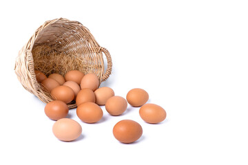Fresh eggs collected outside wicker basket laying on the floor, suitable as a food ingredient. Fresh eggs from quality organic farms isolated on white background with copy space. Healthy food concept