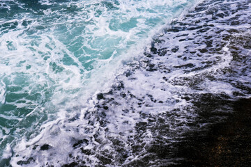 Sea wave on the black sand coastline
