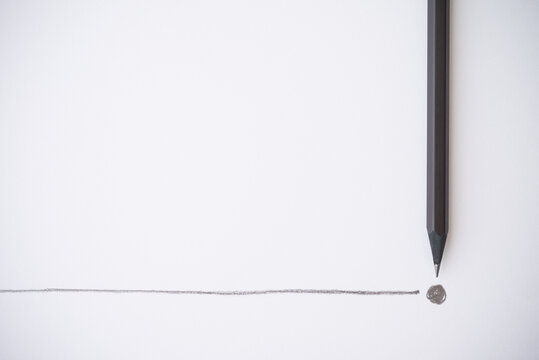 Flat lay of black colour pencil write line and end point on white paper background copy space. Business conclusion, creative idea, imagination and education concept.