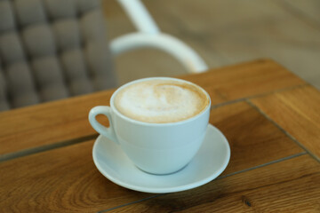 Cup of coffee on wooden table in restaurant