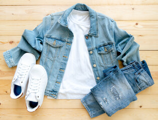 flat lay, White tshirt mockup, denim jacket jeans and shoes on brown wooden background.