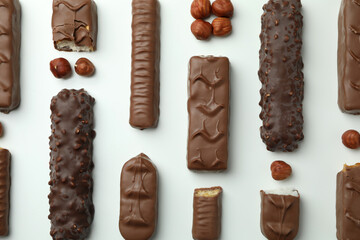 Different tasty candy bars on white background