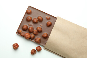 Tasty chocolate bar in paper on white background