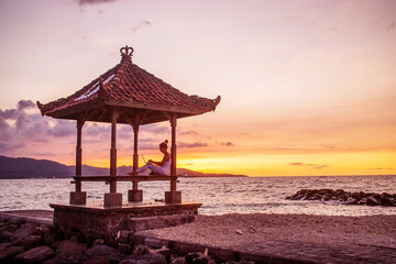Woman by the ocean working on a laptop