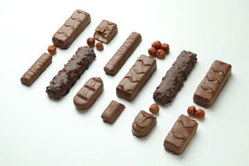 Different tasty candy bars on white background