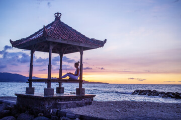 Woman by the ocean working on a laptop