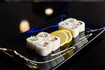 Sushi rolls on black dish. Japanese food.