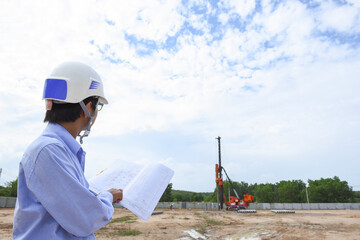 Young engineer checking progress pile driving of diesel hammer pile driving machine working on...