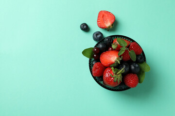Bowl with berry mix on mint background