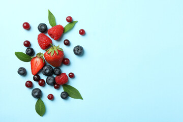 Naklejka na ściany i meble Delicious fresh berry mix on blue background