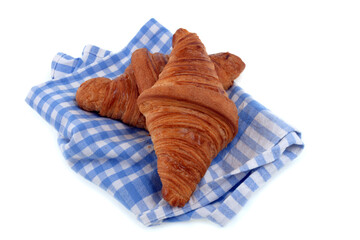 Fototapeta na wymiar Croissants au beurre posés sur une serviette à carreaux en gros plan sur fond blanc