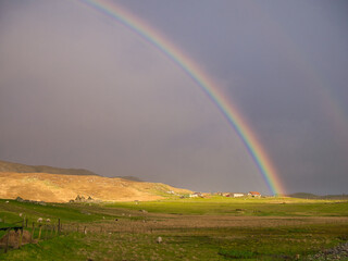 Sunlight and rain giving a bright rainbow at Westing on the island of Unst in Shetland.