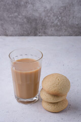 sugar cookies with a glass of tea, baked sweet biscuits at the tea time, on a white texture surface