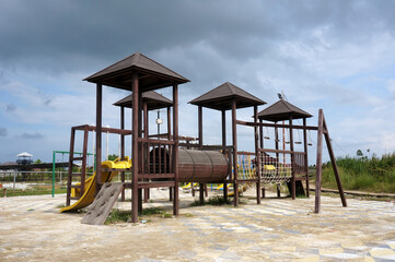 Fototapeta na wymiar Children's wooden playground recreation area at public park 